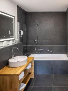 ein Badezimmer mit einem Waschbecken und einer Badewanne in der Unterkunft Bergdorf Spessart in Flörsbachtal