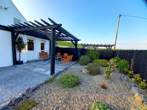 a backyard with a wooden pergola and a patio at Limestone Lodge Apartment in Doolin