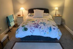 a bedroom with a bed with a floral bedspread at 2x King Bedrooms, private living room & bathroom in Thornhill