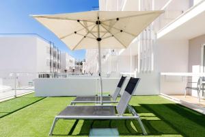 a patio with a chair and an umbrella at Aparthotel y Hotel Paguera Beach in Paguera