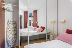 - une chambre avec 2 lits et un miroir dans l'établissement BJØRVIKA APARTMENTS - Solli, à Oslo