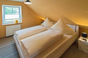 Postel nebo postele na pokoji v ubytování Ferienhaus-Waterkant-bis-6-Personen-mit-Garten