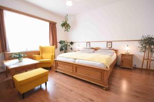 a bedroom with a large bed and a yellow chair at Hotel Diana in Prague