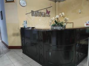 OYO 90529 Hotel Baruga Makassar في ماكاسار: كونتر أسود مع إناء من الزهور عليه