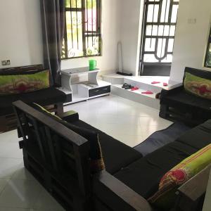 a living room with chairs and a couch and windows at Arusha Holiday Safari in Arusha