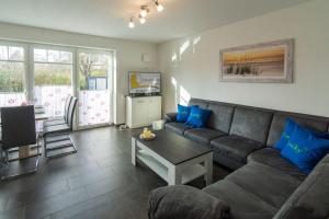 un salon avec un canapé et une table dans l'établissement Ferienhaus-Lucky-bis-6-Personen-mit-Garten-und-Haustier, à Norddeich
