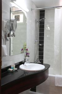 uma casa de banho com um lavatório e um chuveiro em The Eclipse Boutique Suites em Abu Dhabi