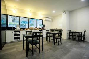 a dining room with tables and chairs in a kitchen at SR Grand Hotel Chiangmai in Chiang Mai