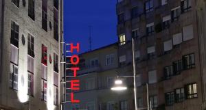 a neon sign in the middle of a building at night at Hotel City Express Comercio in Pontevedra