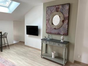 a living room with a mirror and a table at Au coin des Hospices in Beaune