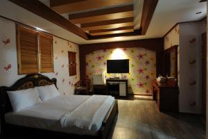 a bedroom with a bed and a desk and a television at Galleria Hotel in Andong