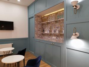 a meeting room with tables and chairs and a wall with glass at 3 Rooms Hotel in Tbilisi City