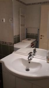 une salle de bain avec un lavabo blanc et un miroir dans l'établissement Boróka 2 Apartman, à Hajdúszoboszló