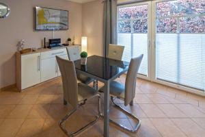 ein Esszimmer mit einem Tisch mit Stühlen und einem Laptop in der Unterkunft Ferienwohnung Ambiente in Norddeich