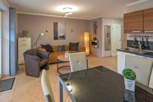 eine Küche und ein Wohnzimmer mit einem Sofa und einem Tisch in der Unterkunft Ferienwohnung Ambiente in Norddeich