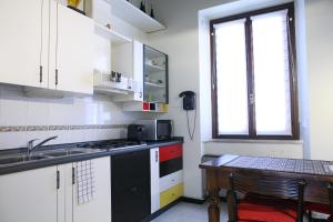 kuchnia ze zlewem, kuchenką i stołem w obiekcie BnButler - Navigli Apartment - Vicolo Lavandai w Mediolanie