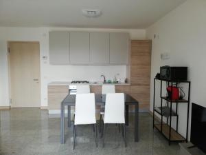 a kitchen with a dining room table and white cabinets at Appartamento La Terrazza in Riva del Garda +12 photos