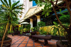 un patio con plantas y un banco frente a un edificio en Sathorn Saint View Serviced Apartment, en Bangkok