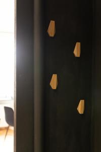 a wall with wooden wall hooks on a black wall at Apartament nad Motławą in Gdańsk
