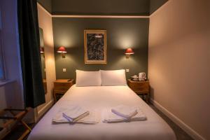 1 dormitorio con 1 cama con 2 toallas en Douglas Arms Hotel, en Castle Douglas