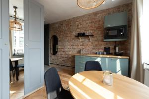 a kitchen with a wooden table and a brick wall at Apartament nad Motławą in Gdańsk