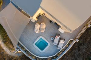 een uitzicht over een zwembad met een paar schoenen bij Villa Vinea Santorini in Imerovígli