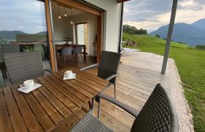 a wooden deck with a table and chairs on it at Alpine Chalet Aurora Dolomites in Laion