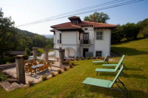 a house with chairs and tables in a yard at Villa Victoria in Vallobal