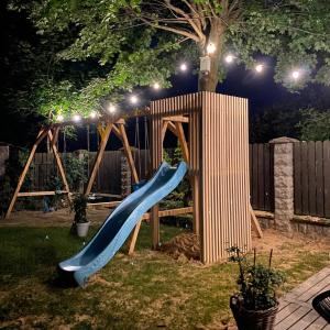 a playground with a slide in a yard at night at Apartamenty Rajcza in Rajcza