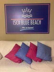 a sign above a bed with three pillows on it at ISCA BLUE BEACH Casa in Villa con ampio spazio esterno vicino al mare, sino a max 8 persone in Isca sullo Ionio