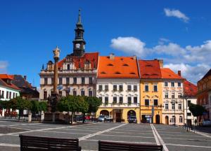 a large building with a clock tower in a street at Apartmány LUXOR in Česká Lípa
