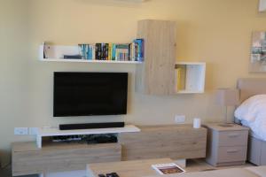 TV in/ali zabaviščno središče v nastanitvi Wileg 4A Luxury Studio Apartment with Shared Swimming Pool.