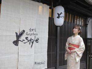 a woman in a kimono standing in front of a banner at K-style kinkakuji in Kyoto