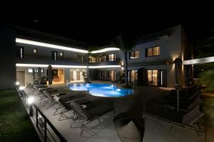 a house with a swimming pool at night at Allonda Seafront Experience in Stavros