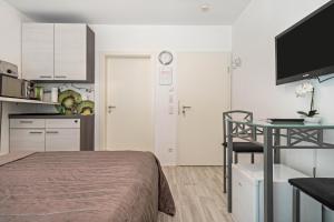 a bedroom with a bed and a table and a kitchen at Apartment mit Kaffeeküche für Zwei in Meersburg