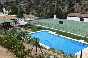 einen Pool mit einem Tennisplatz und einem Basketballplatz in der Unterkunft CASA RURAL LA PILONGA DE PARAUTA in Parauta