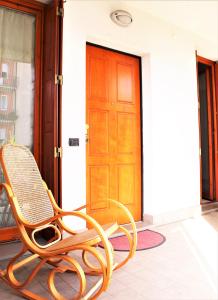 una silla de madera en el porche de una casa en Appartemento Stella en Bérgamo