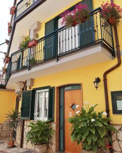 a yellow house with a balcony with flowers on it at La corte del Campo in Cava deʼ Tirreni