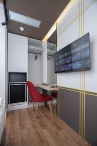 a living room with a red chair and a desk at Hotel PortSide GF in Vlorë +25 photos