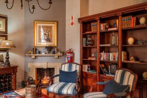 a living room with two chairs and a fireplace at Van der Stel Manor in Stellenbosch