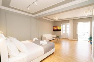 a white bedroom with a bed and a living room at THE YDRA VIEW APARTMENTS in Hydra