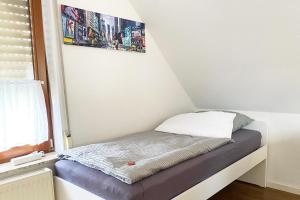 uma pequena cama num quarto com uma janela em Schönes 1 Zimmer Apartment mit Dachterrasse em Glauchau