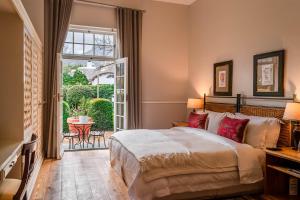 una camera da letto con un letto e una grande finestra di Van der Stel Manor a Stellenbosch Altre 37 foto
