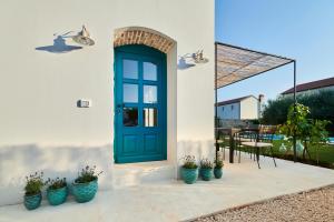 a blue door on a white house with potted plants at VILLA MEDITERANEA in Umag