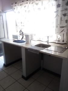a kitchen counter with a sink and a window at The Eden Lodge Boksburg in Boksburg