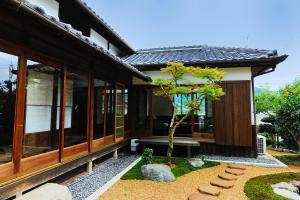 a small tree in front of a house at Kotorian in Asuka