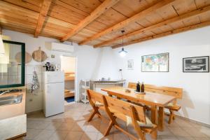 cocina y comedor con mesa de madera y sillas en Villa Anita en Vela Luka