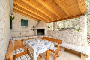 a patio with a table and chairs and an outdoor oven at Villa Anita in Vela Luka