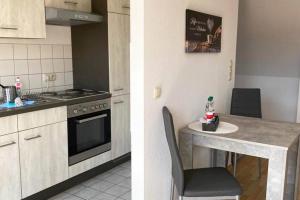 a kitchen with a stove and a table with a chair at Apartment mit Dachterrasse nahe Zwickau in Glauchau