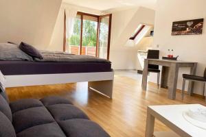 a bedroom with a bed and a table and a desk at Apartment mit Dachterrasse nahe Zwickau in Glauchau